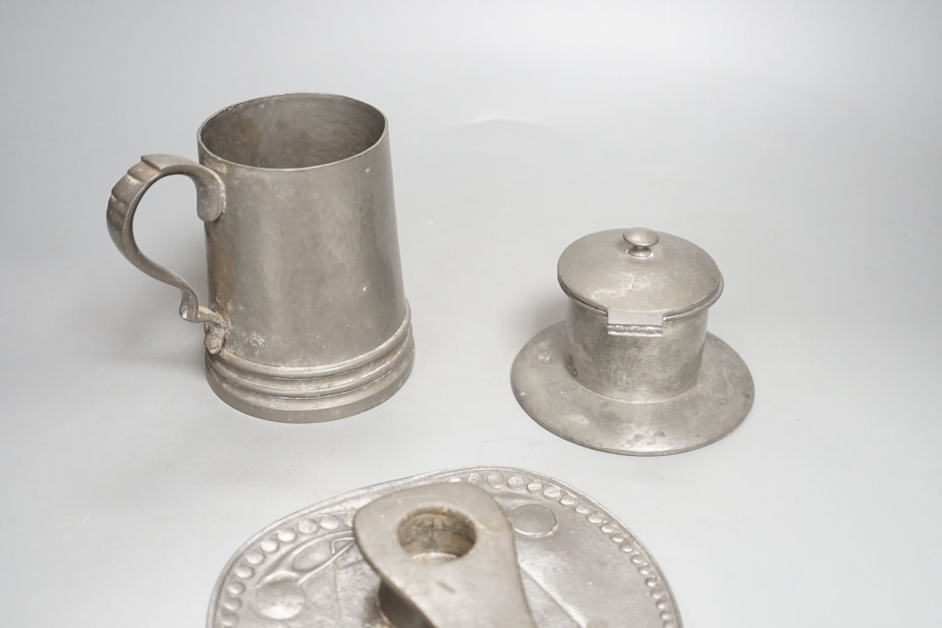 A Liberty Tudric pewter chamberstick, inkwell and mug. Length of chamberstick 18cm, model numbers 0523, 01135, and 01352